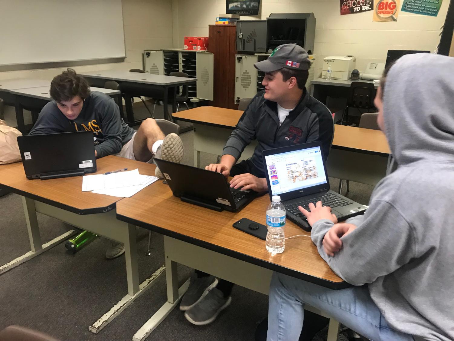 Juniors Carlo Munaco and Domenico Munaco and senior Christian Vataj in their Advanced Marketing and Advertising class utilizing their school-provided technology.