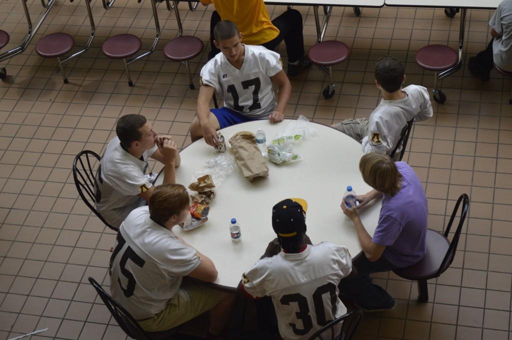 Students eat lunch in the cafeteria. 