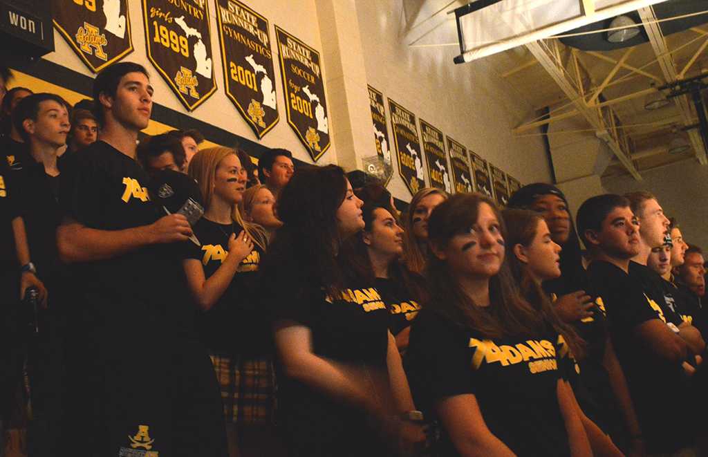 Students stand for the national anthem at the Homecoming Pep Assembly. Standing like this is now commonplace at Adams in lieu of the Pledge of Allegiance mandate. 