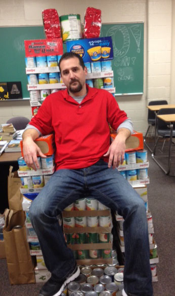 Mr. Lovalvo, the English Departments victorious tribute, sits atop a throne of cans his classes have collected.