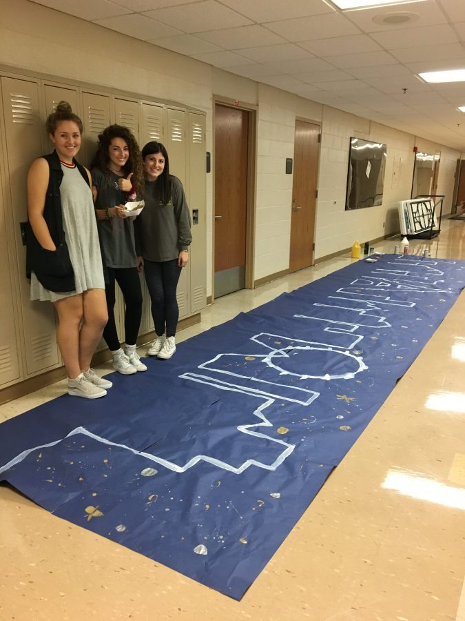 Student Council members ans seniors Kyra Brown (left), Grace Lee (middle), and Allie Ziniti (right), create unique decor to decorate the gymnasium in preparation for the dance.