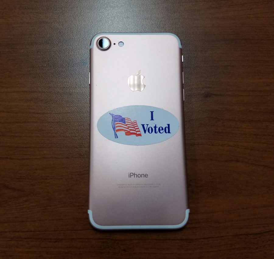 Senior+Shelby+Smith+proudly+displays+her+I+Voted+sticker+on+her+phone.