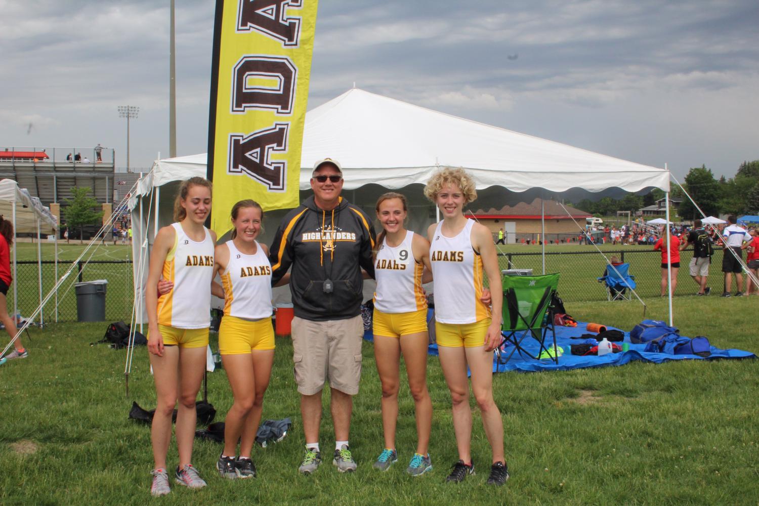 The 4x800m relay team (from left to right, junior Eva Jahnson, senior Hannah Champine, junior Maddie Dessy, and senior Carola Jahnson) pose with Coach Gary Inman at the Division One State Finals meet.