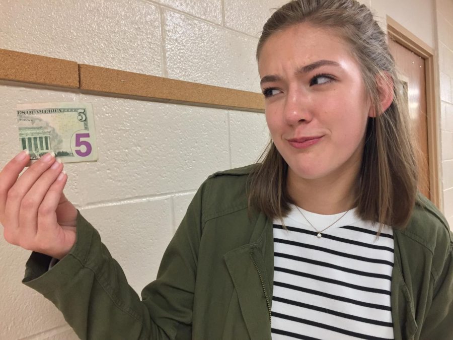 Junior Caitlin Martens flashes another $5 for a school fee.