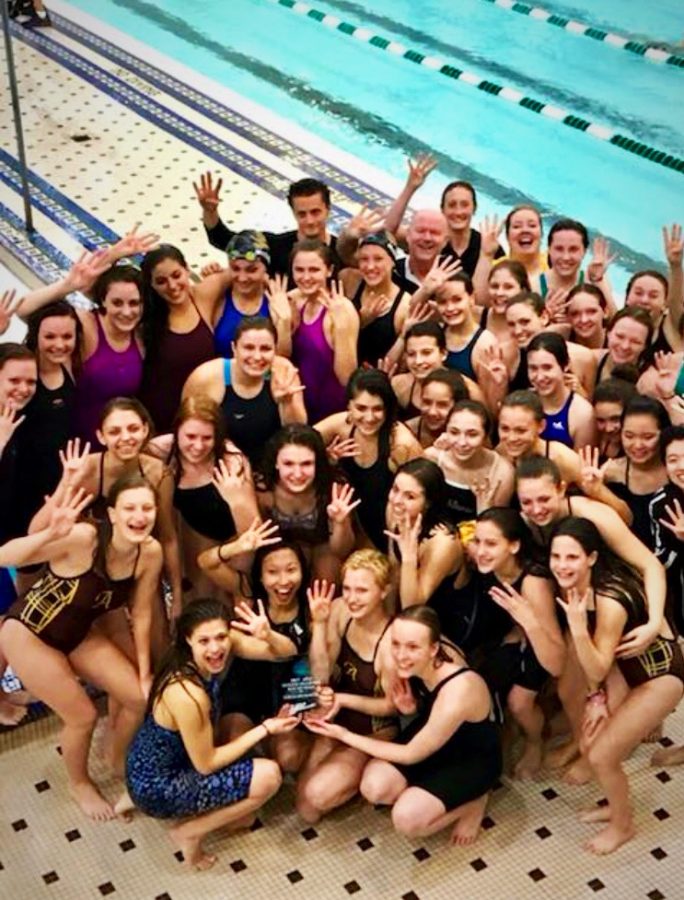 The+Rochester+Adams+Girls+Swim+and+Dive+team+holds+up+four+fingers+in+celebrations+winning+the+League+meet+four+years+in+a+row.+