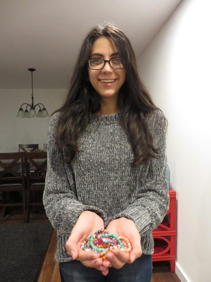 Nasiri holding some of her handcrafted bracelets.