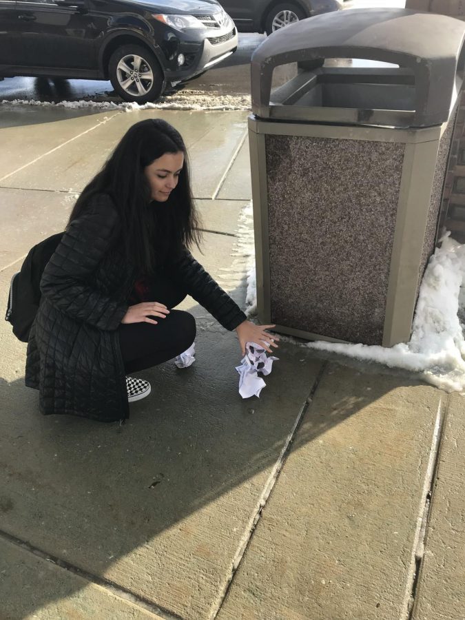 Brina Golubovic picking up trash outside of Adams High School.