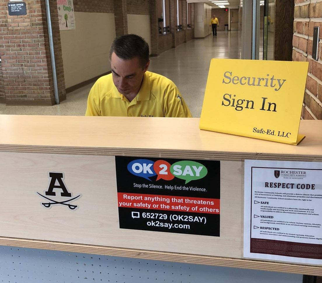 Adams security guard signing in students coming into the school ensuring a safe learning environment.