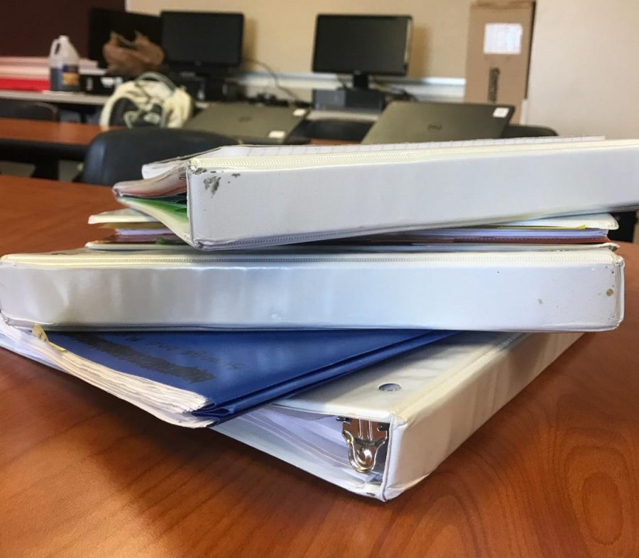 A stack of binders that could be donated.