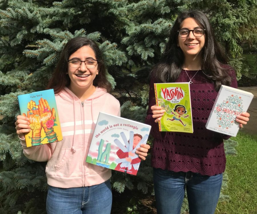 Mena (left) and Zena Nasiri (right) holding some of the books they donated.