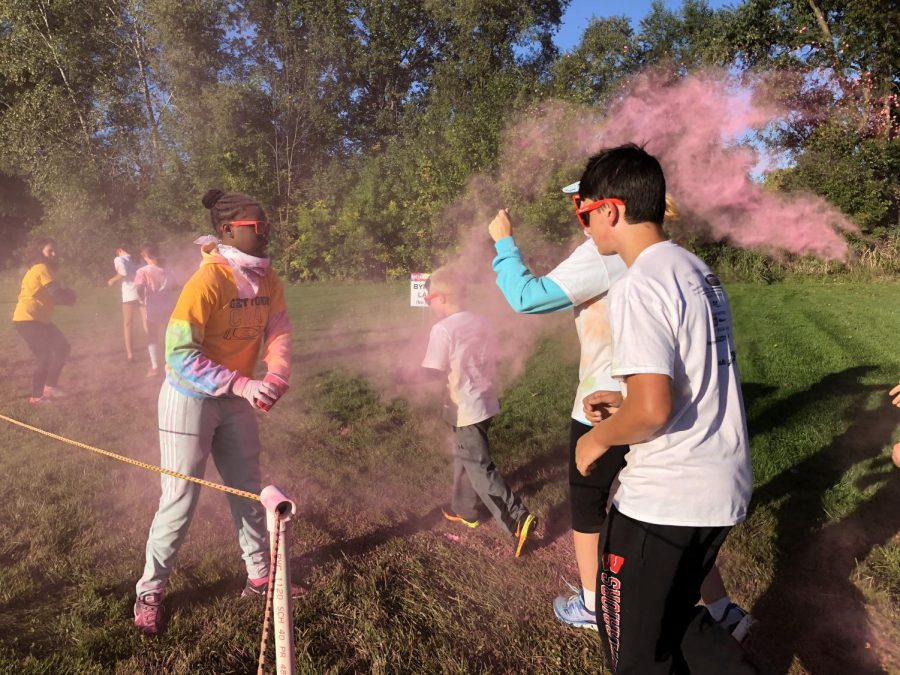 Adams students and family run through pink colored powder during the Color Run.