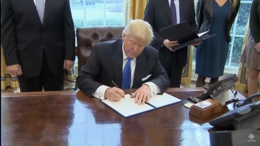 Trump signing the bill to continue building the pipeline.