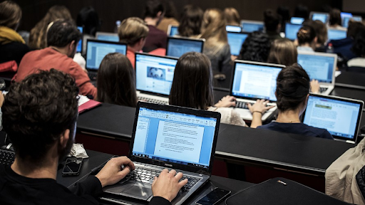 Students on laptops in class using online resources.