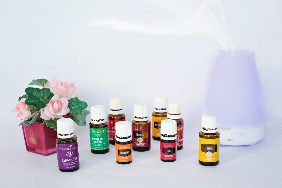 An essential oil diffuser and bottles of essential oils.
