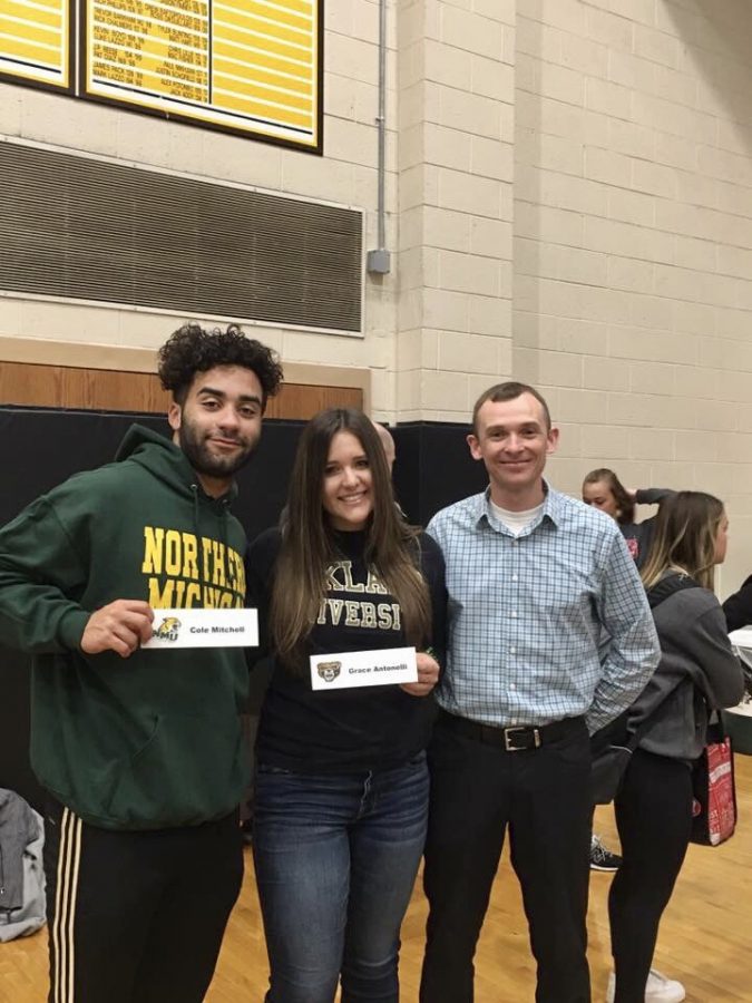 Cole Mitchell, Northern football commit and Grace Antonelli Oakland University Track and Field commit pose with head Track and Field coach, Eric Lohr.