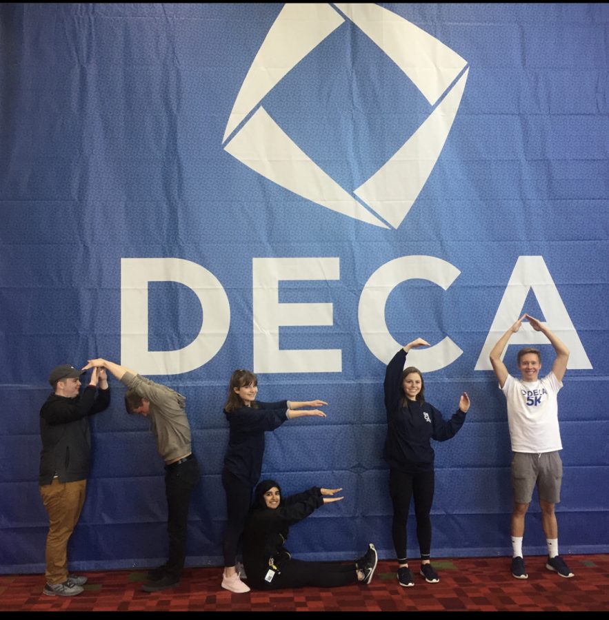 Members spelling out DECA in front of the DECA logo