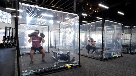 Image of a gym located in california taking serious precautions towards the Coronavirus with isolating customers working out in their own “pods”.