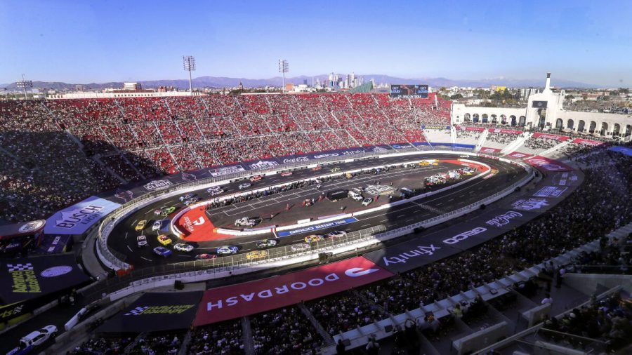 Cars race around the temporary track built inside the LA Coliseum on February 6, 2022. (Photo Credit: Los Angeles Times)