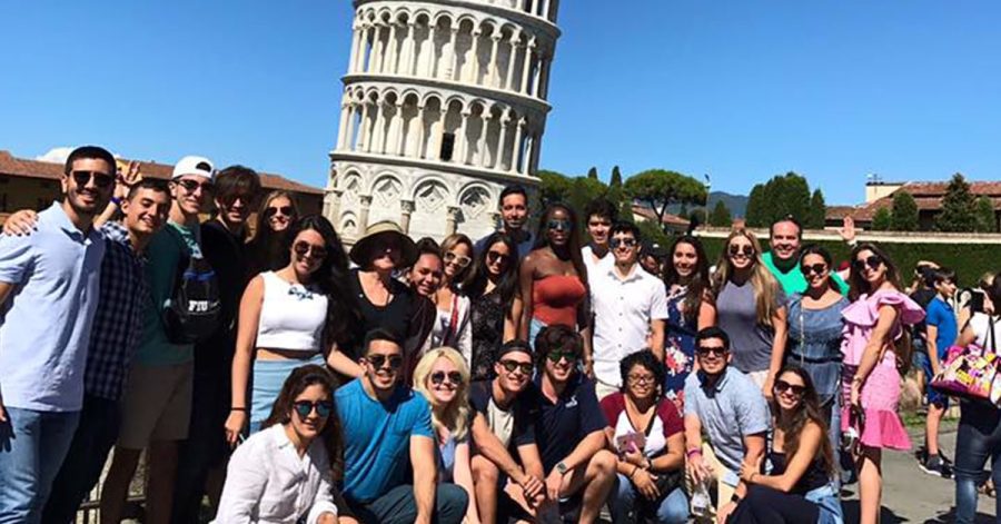 Students who decide to study abroad all gather and pose 
in front of a famous building.